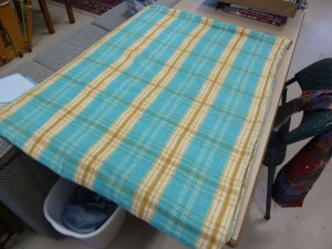 The blue blanket before sewing in a tube and cutting the strups