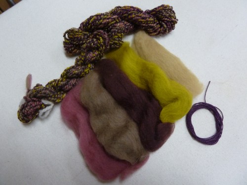 5 colors of merino top, a commercial rayon yarn, and samples of finished cabled yarn