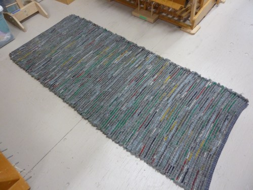 R186 - a long rug, gray fringe alternated with colorful wooly worms